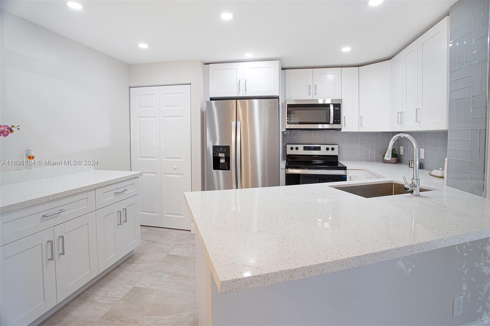 a kitchen with stainless steel appliances a refrigerator sink and microwave