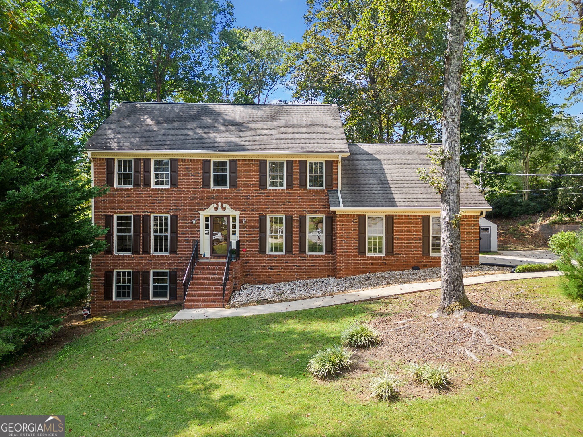 a front view of a house with a garden