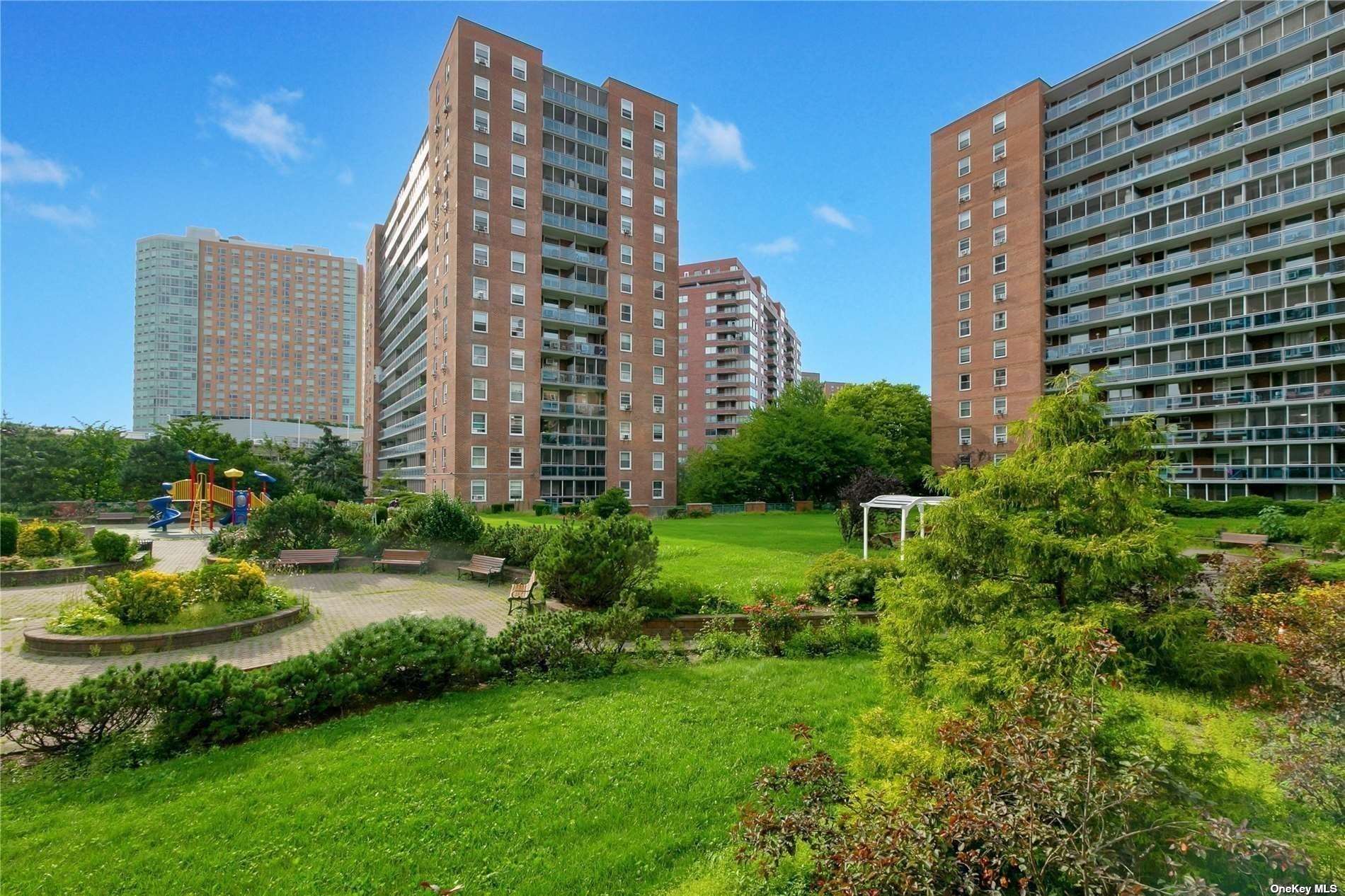 a view of a tall building next to a yard