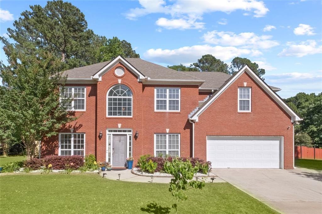 a front view of a house with a yard and garage