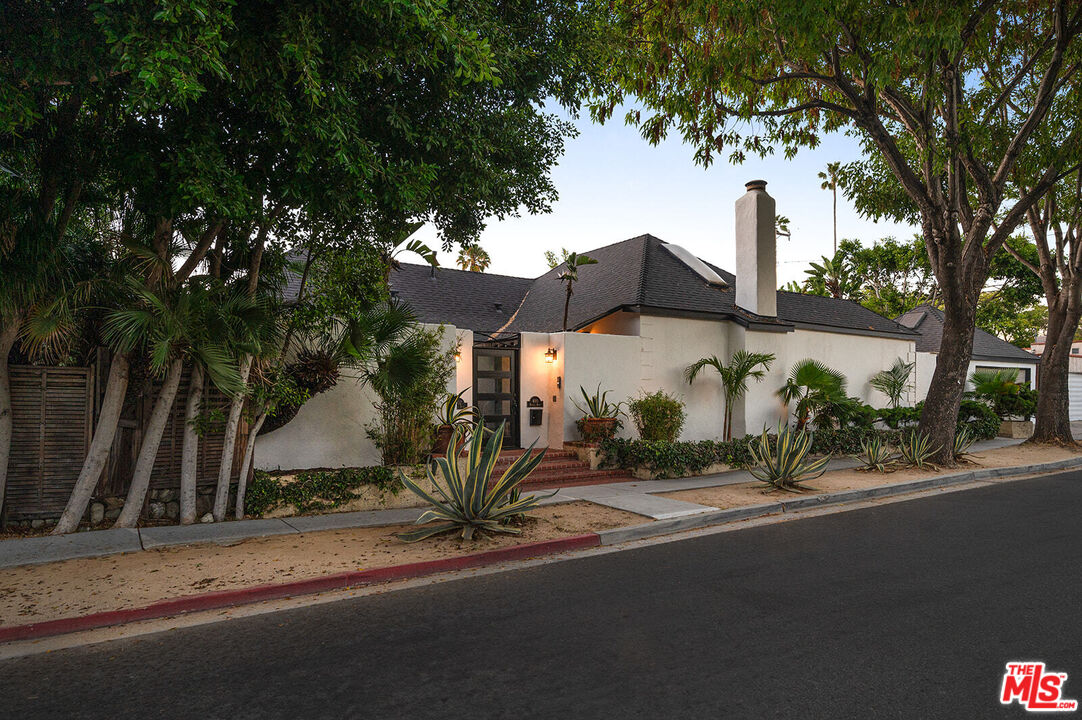 a front view of a house with a yard and tree s