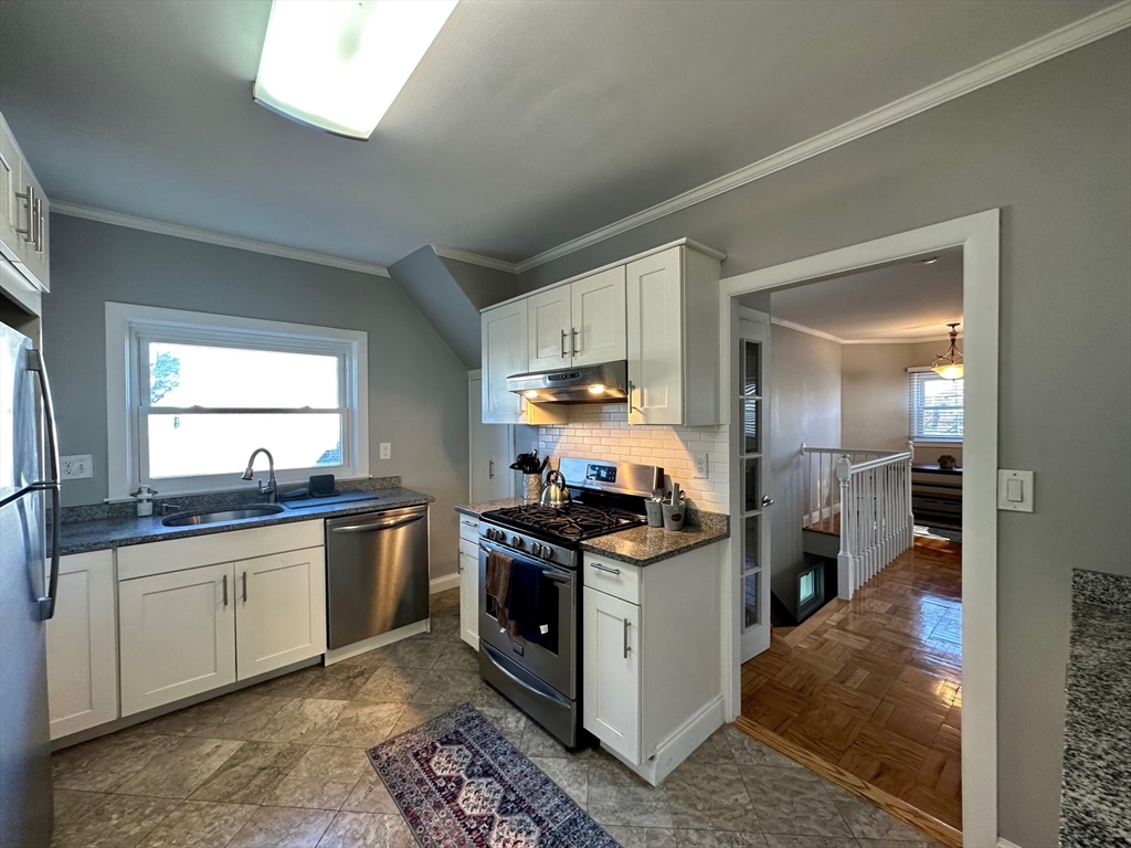 a kitchen with stainless steel appliances granite countertop a sink stove and refrigerator