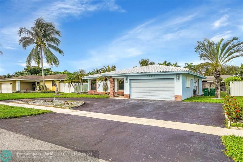 a view of a house with a yard and palm trees