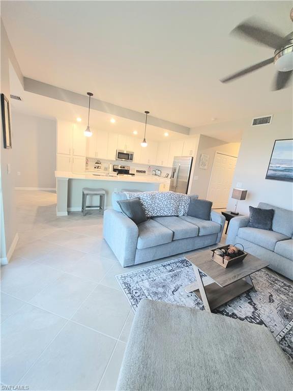 Kitchen featuring sink, appliances with stainless steel finishes, decorative backsplash, and white cabinets