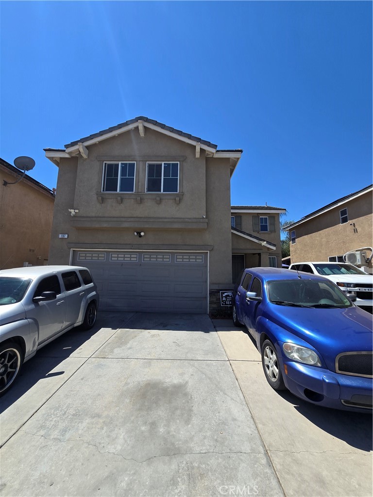 a front view of a house with cars parked