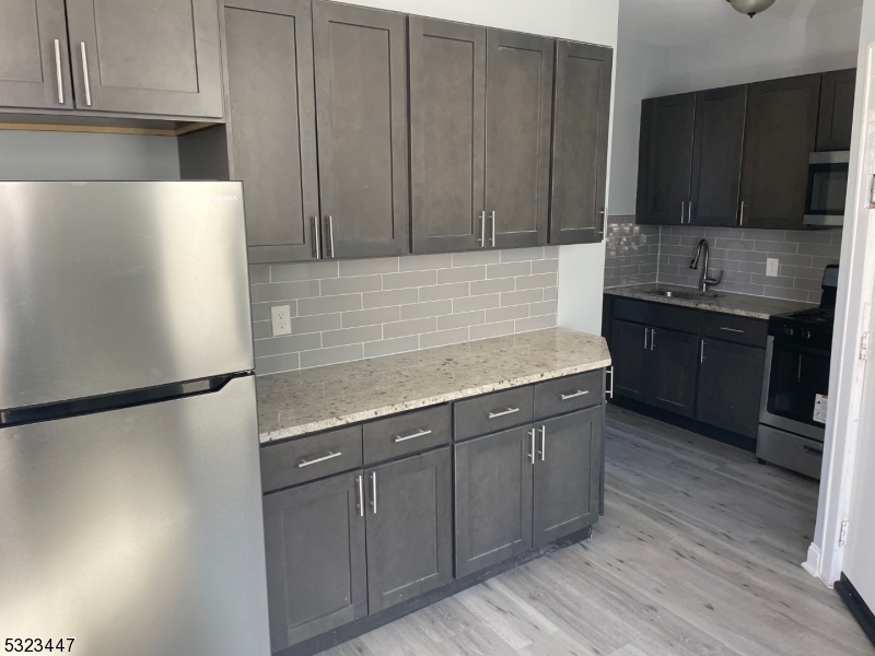 a kitchen with stainless steel appliances granite countertop a refrigerator sink and cabinets