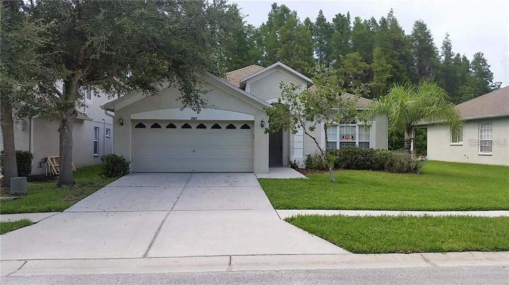 a front view of a house with a yard and a garage