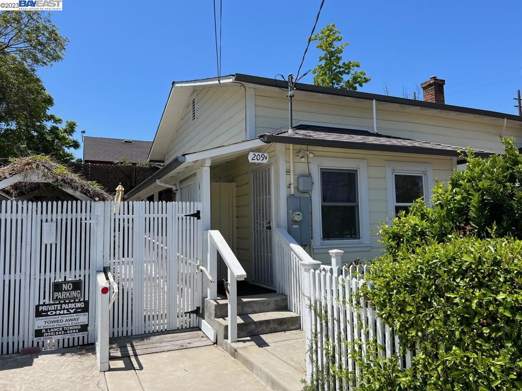 a view of a house with a small yard and wooden fence