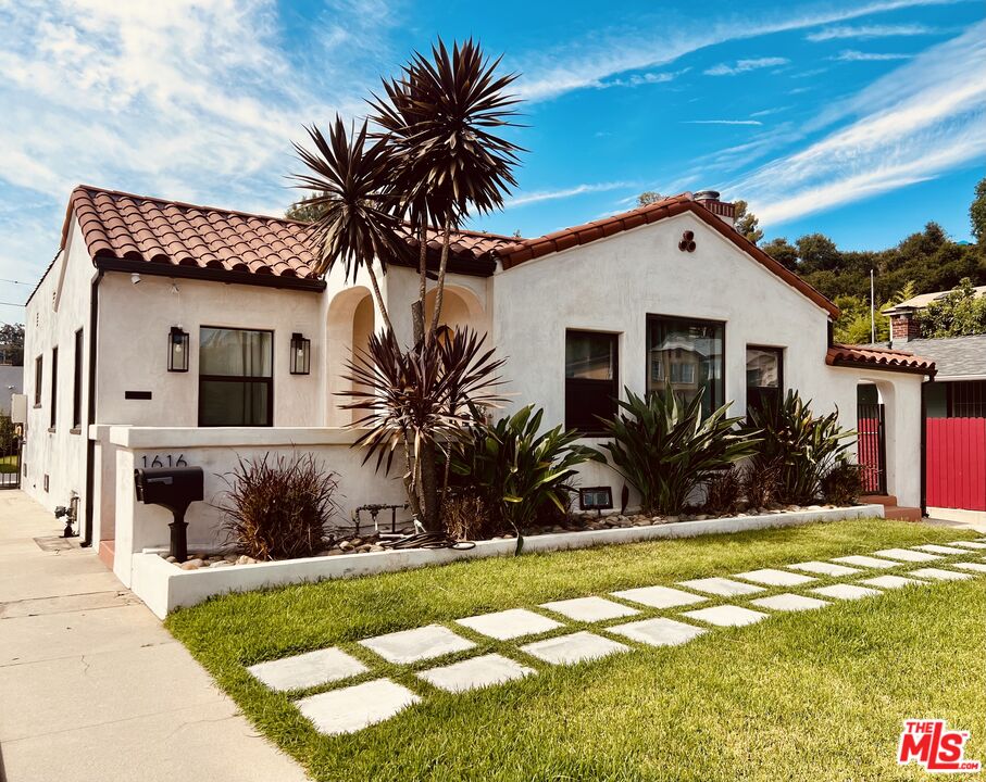 a palm tree in front of a house with a yard