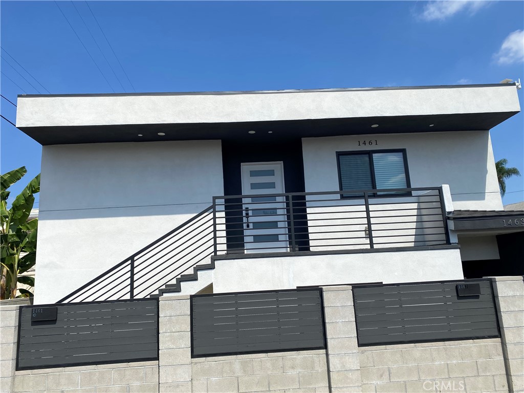 a backyard of a house with wooden fence and large windows