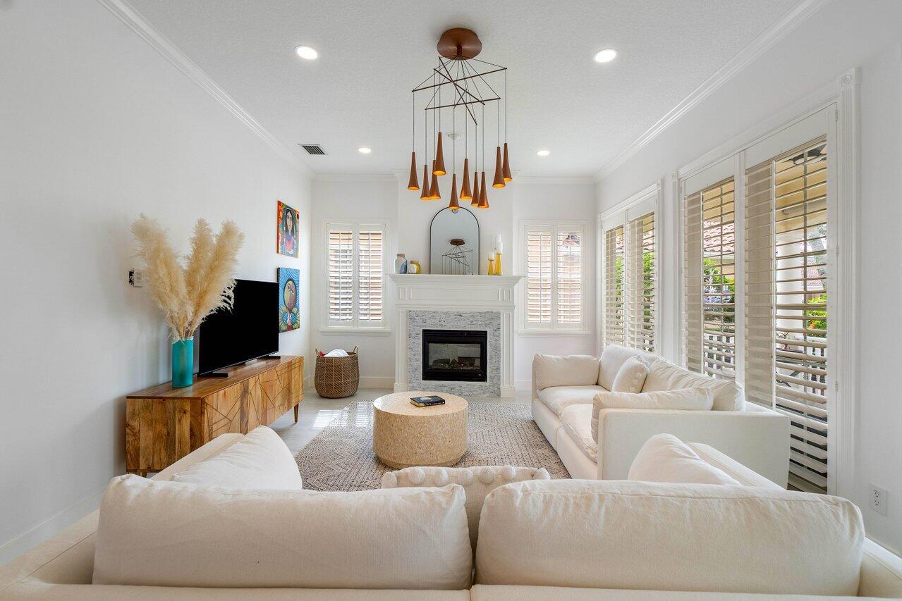 a living room with furniture a fireplace and a chandelier