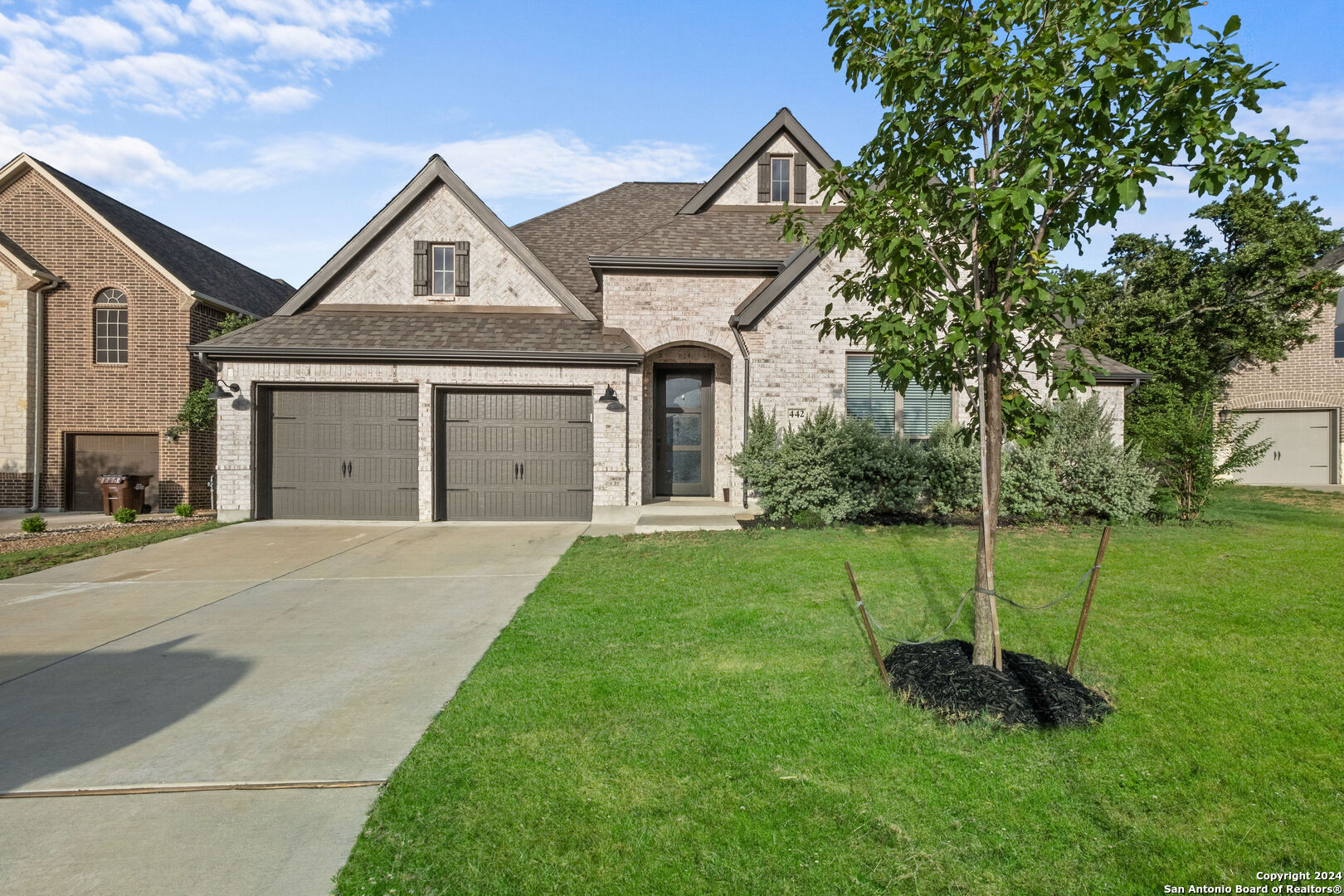 a front view of a house with a yard and garage