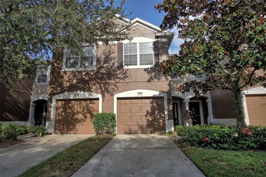 front view of a house with a yard and an trees