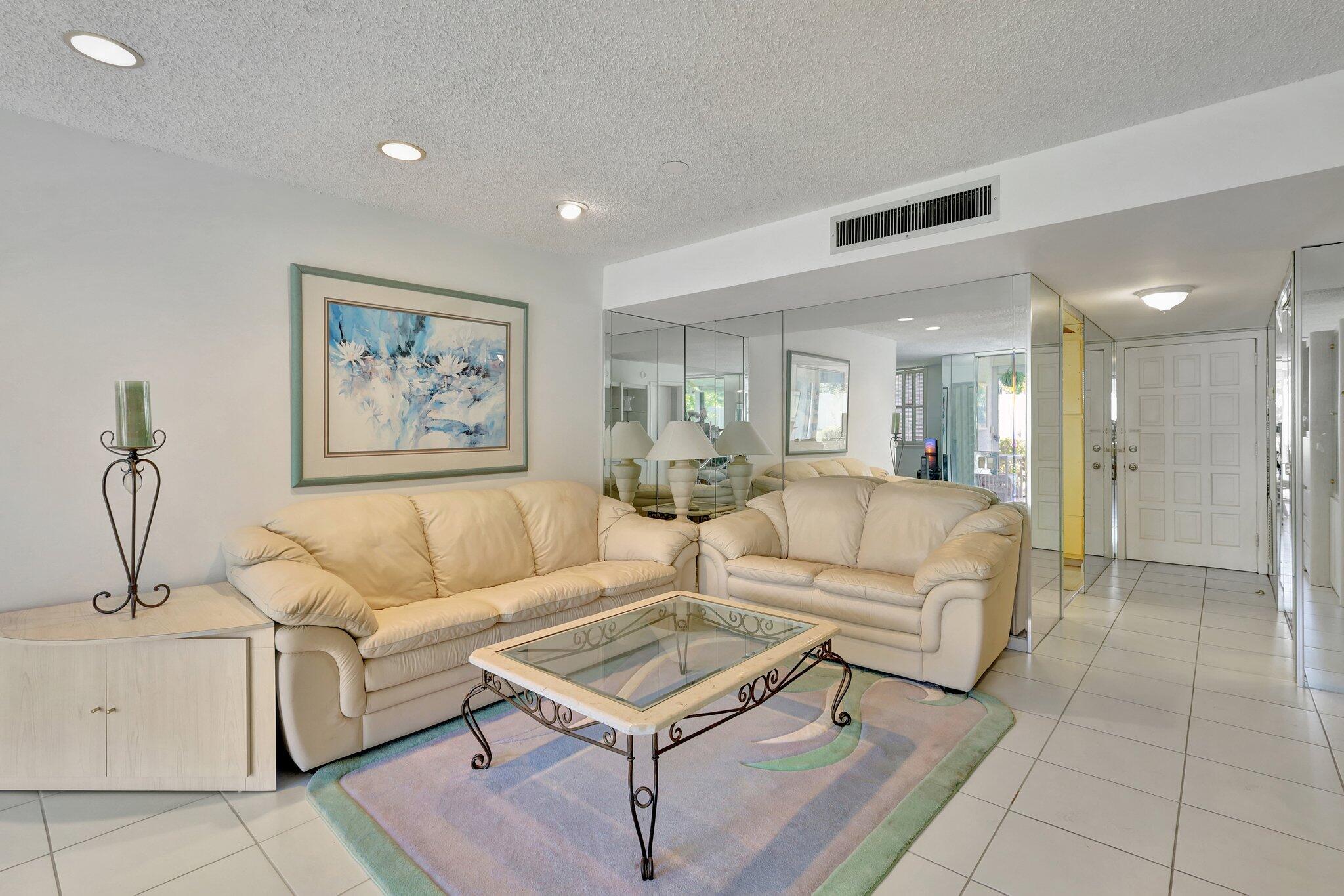 a living room with furniture and a view of kitchen