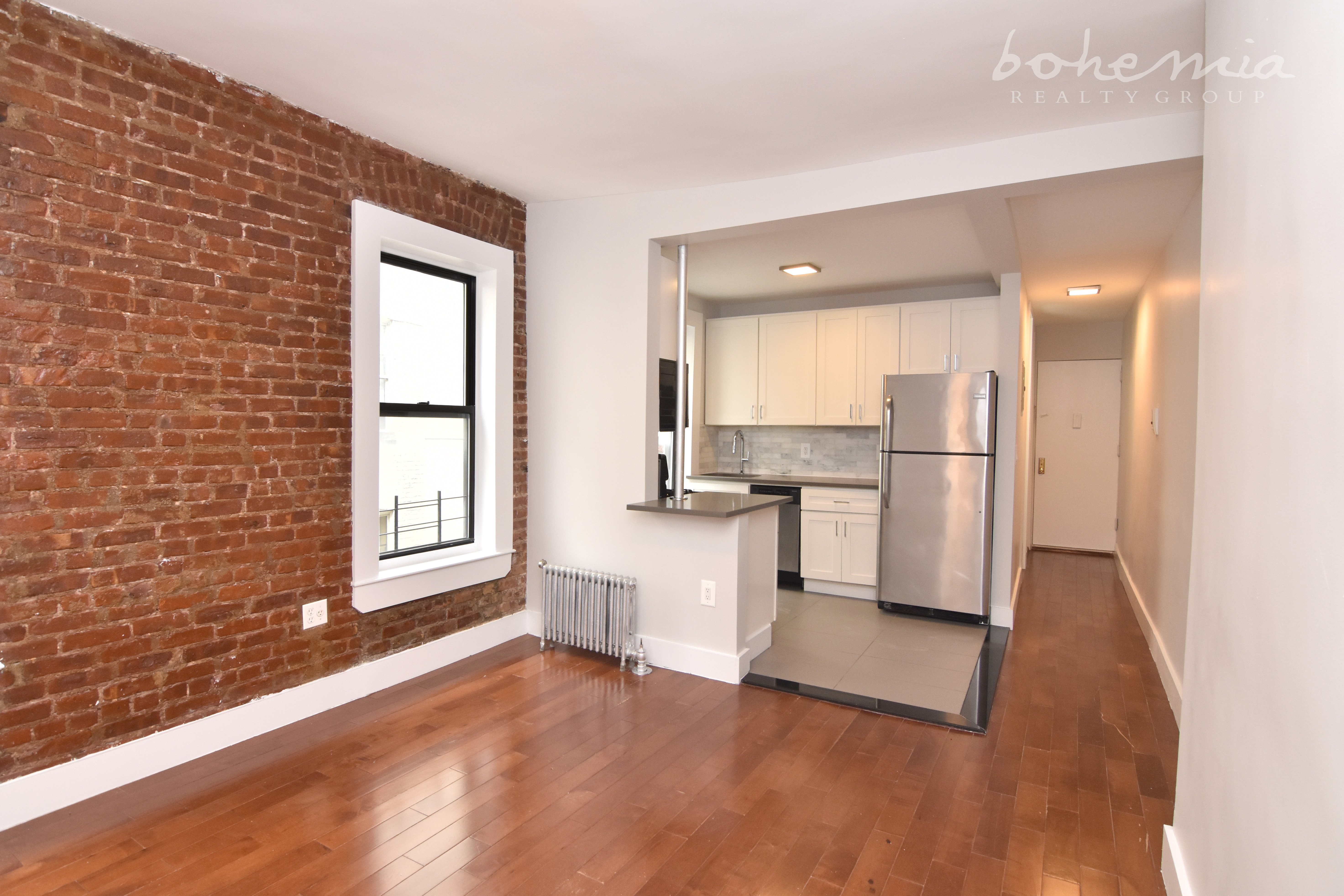 a kitchen with a refrigerator and white cabinets