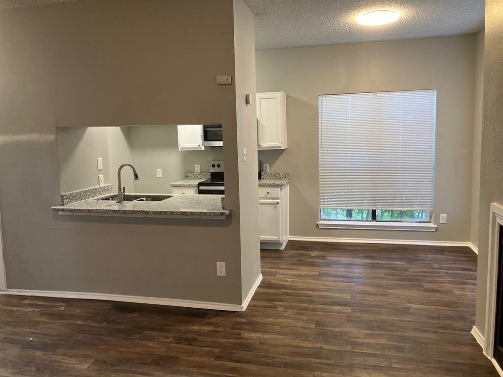 a room with a sink cabinets and wooden floor