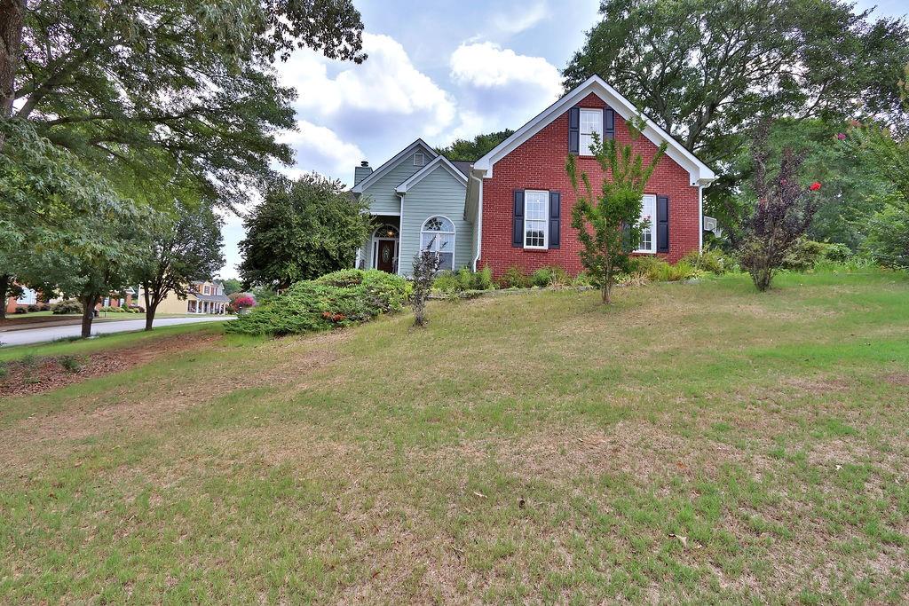 a view of a house with a yard and tree s