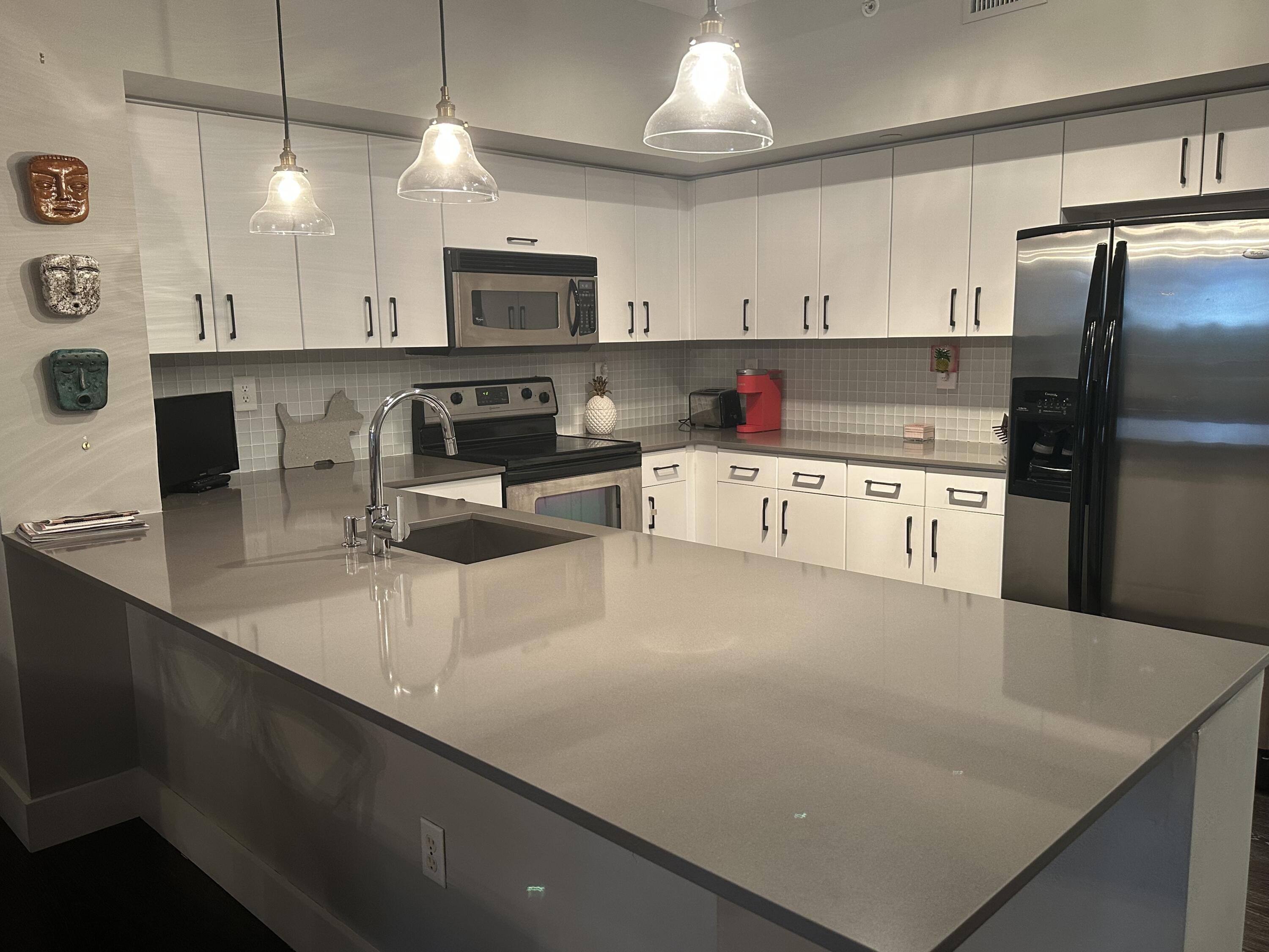 a kitchen with stainless steel appliances a stove a sink a microwave a refrigerator and cabinets