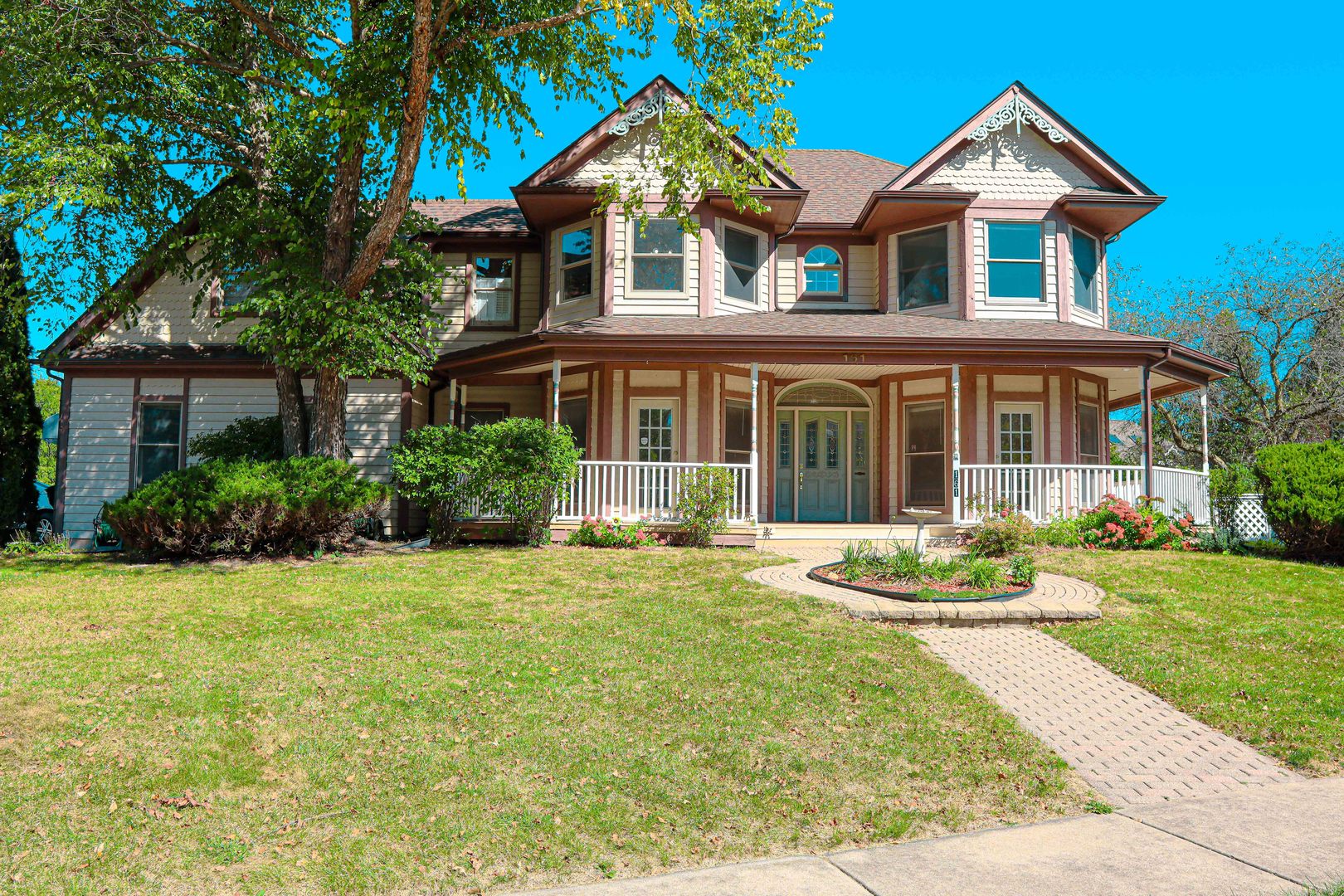 a front view of a house with a yard and potted plants