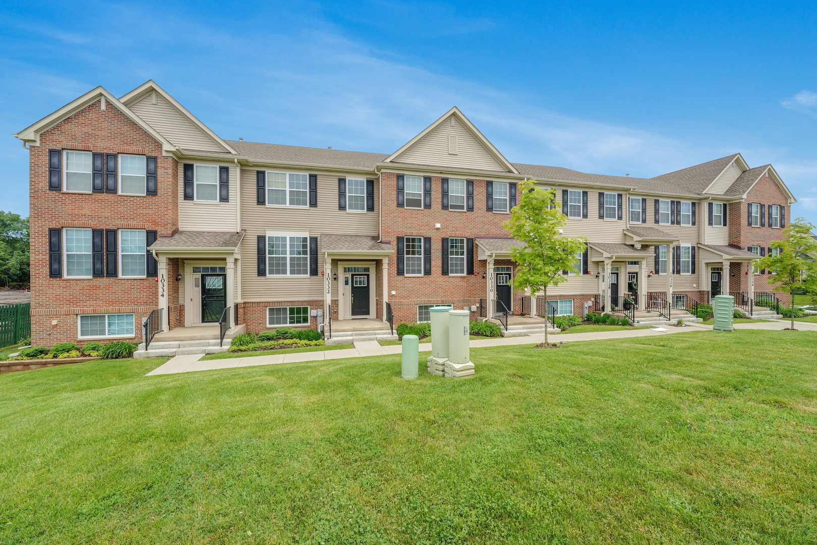 a front view of a residential apartment building with a yard