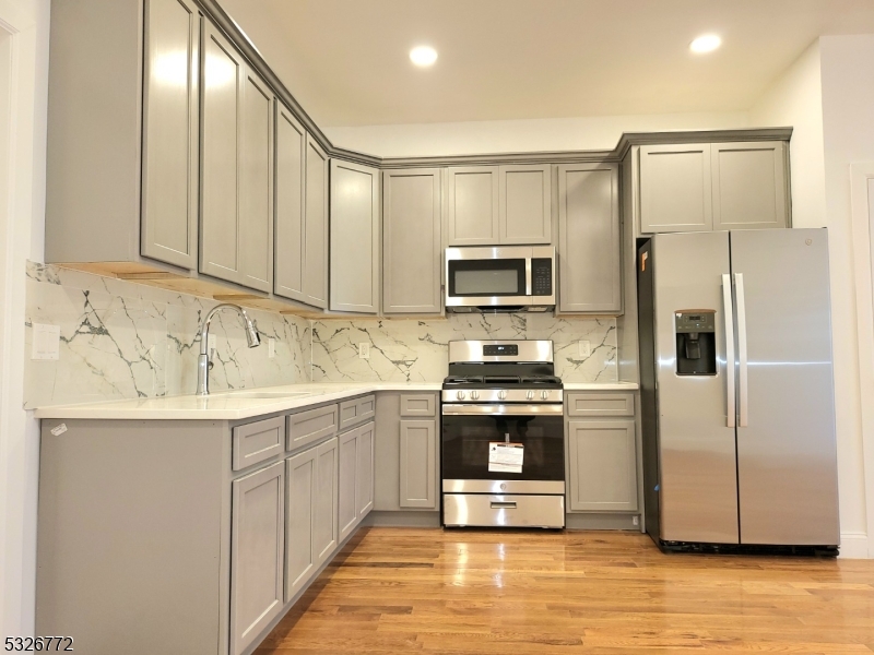 a kitchen with stainless steel appliances a stove sink and refrigerator