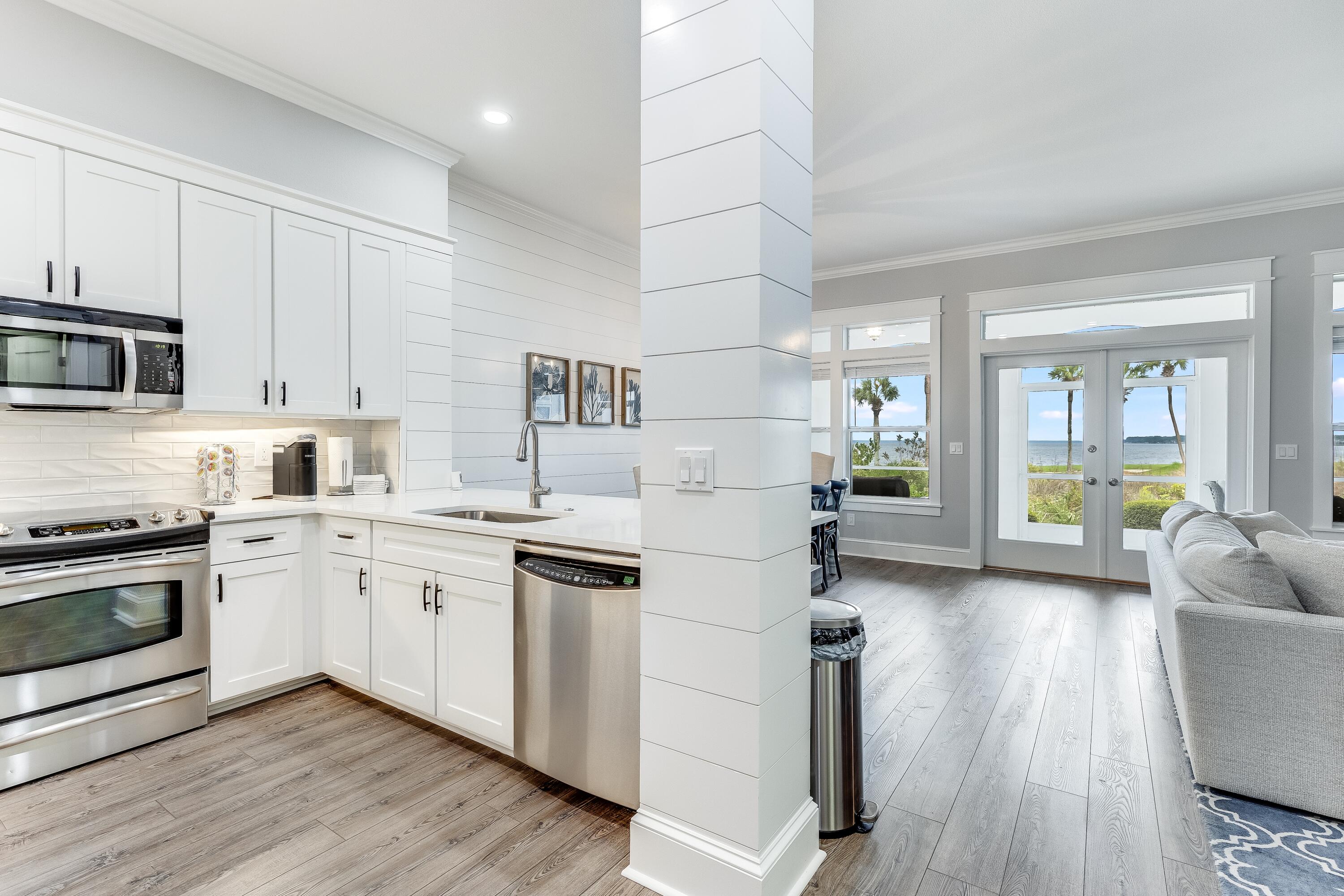 a kitchen with stainless steel appliances granite countertop hardwood floor sink stove dining table and chairs