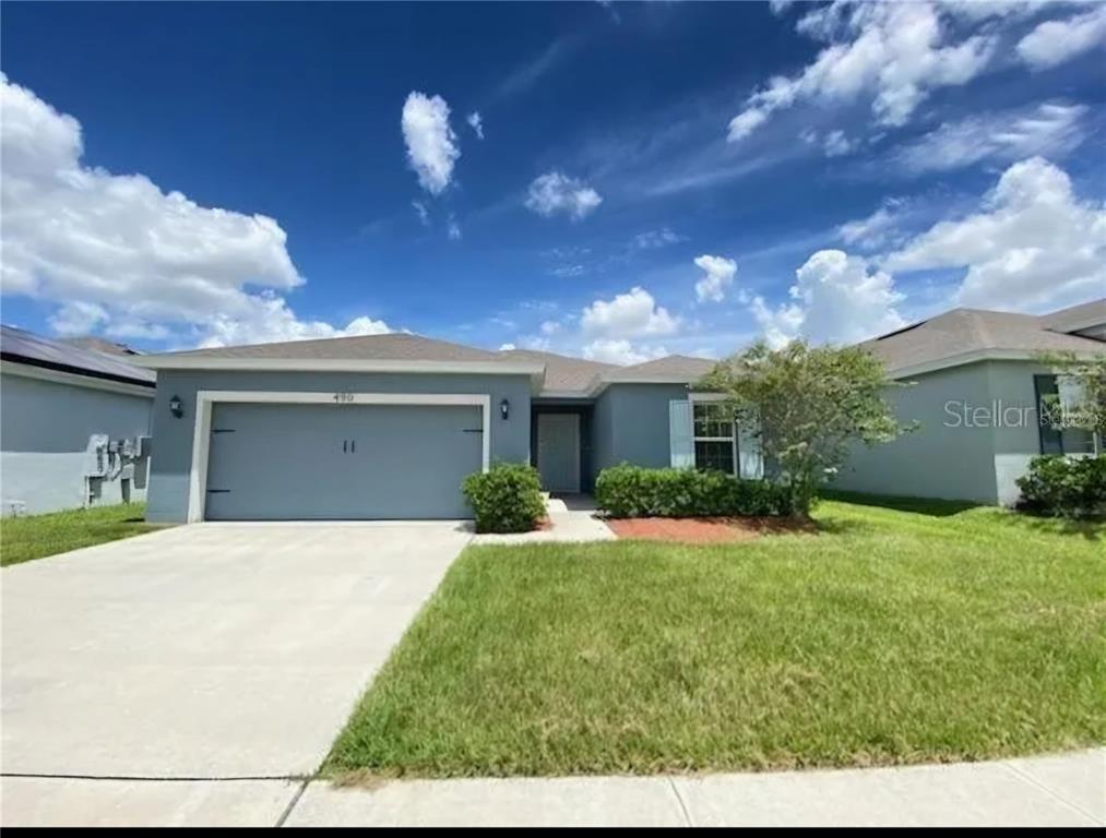 a front view of a house with a yard and garage