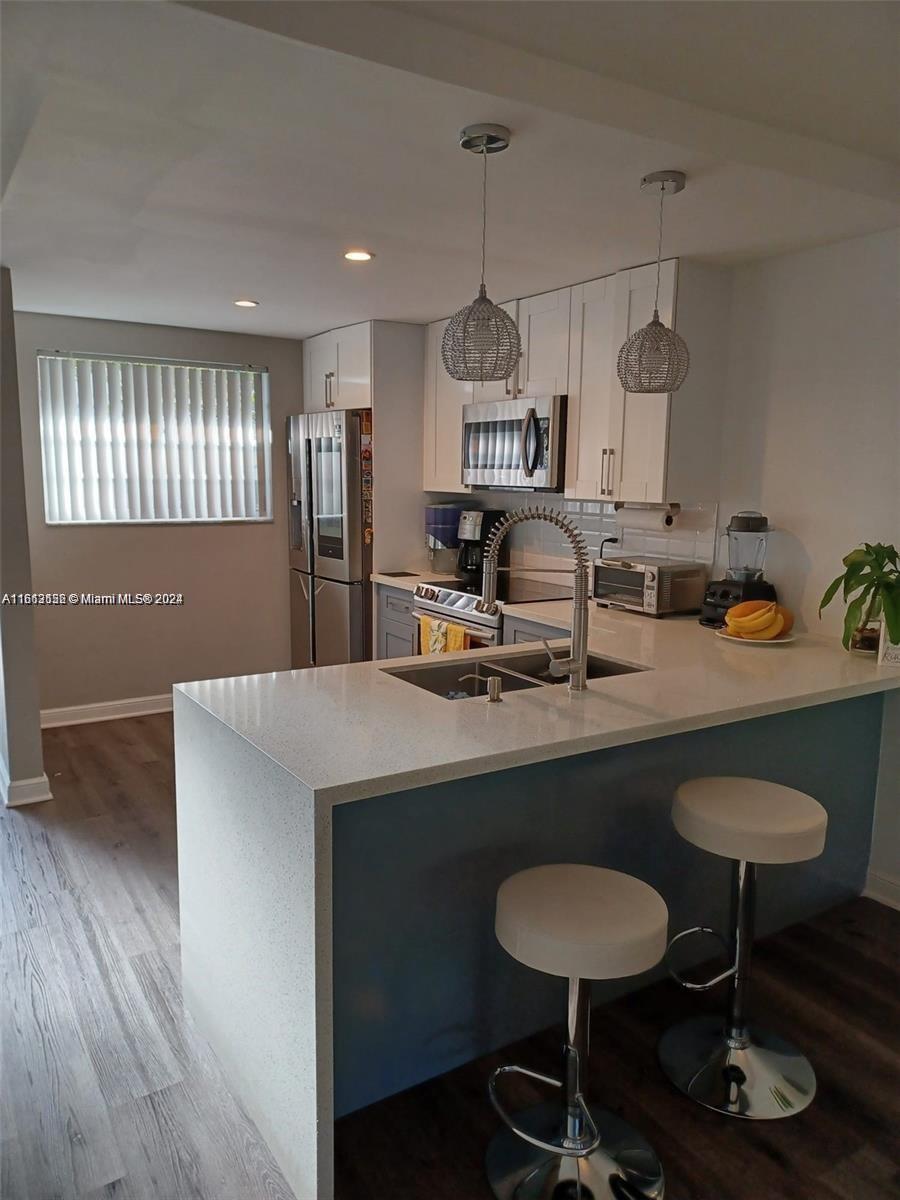 a kitchen with kitchen island a sink table and chairs