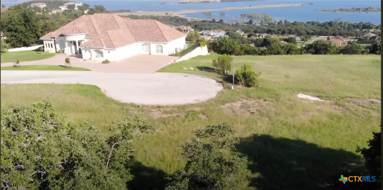 an aerial view of a house with a yard and lake view