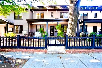 a front view of a residential apartment building with a bench