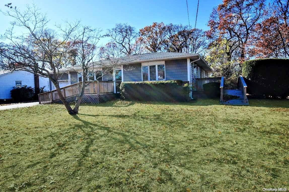 a view of a house with a yard and a tree