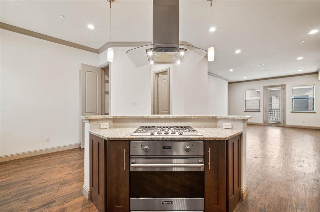 a kitchen with a stove and a wooden floor