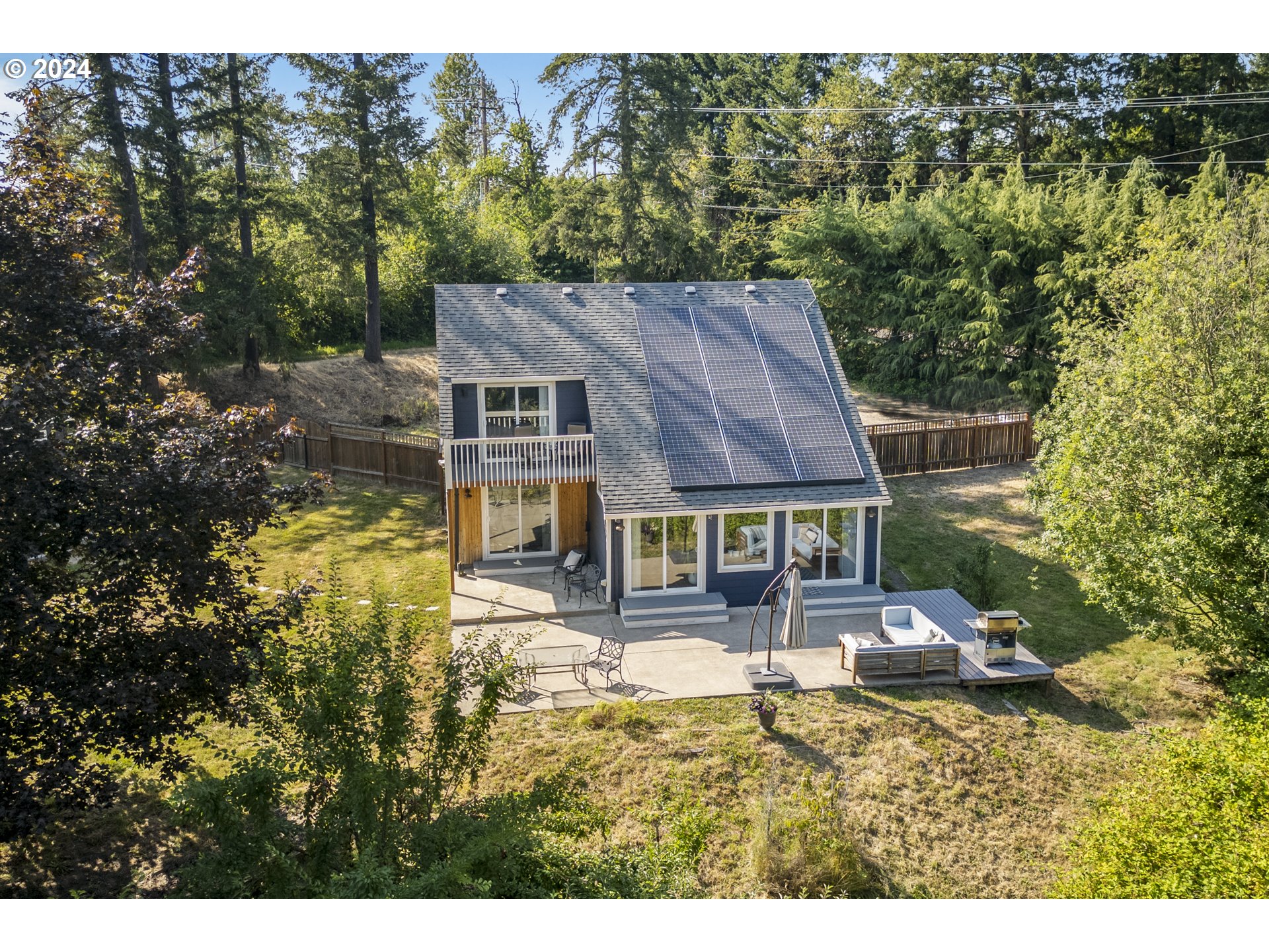 a aerial view of a house with swimming pool next to a big yard