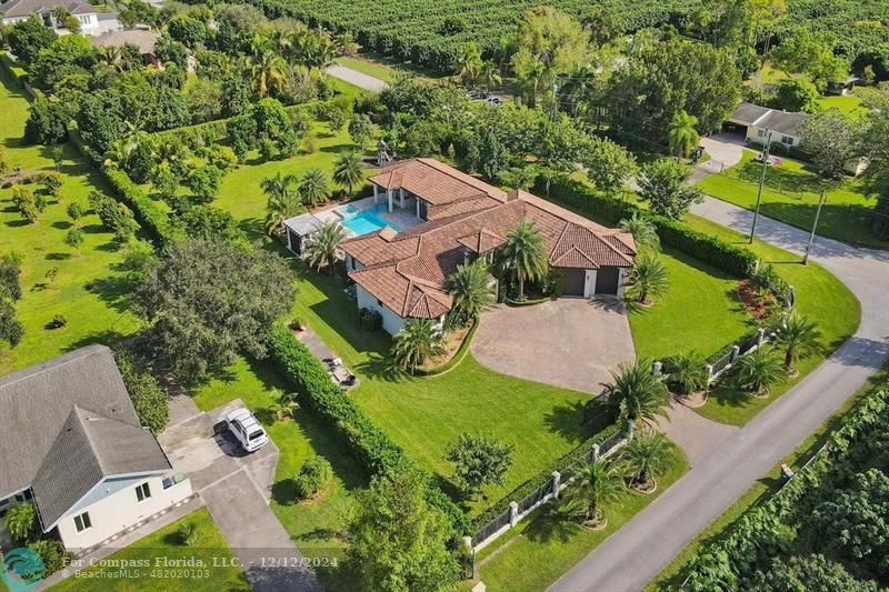 an aerial view of a house with a garden and swimming pool