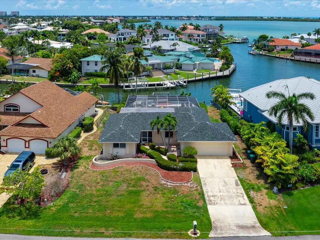 an aerial view of a house with a garden and lake view