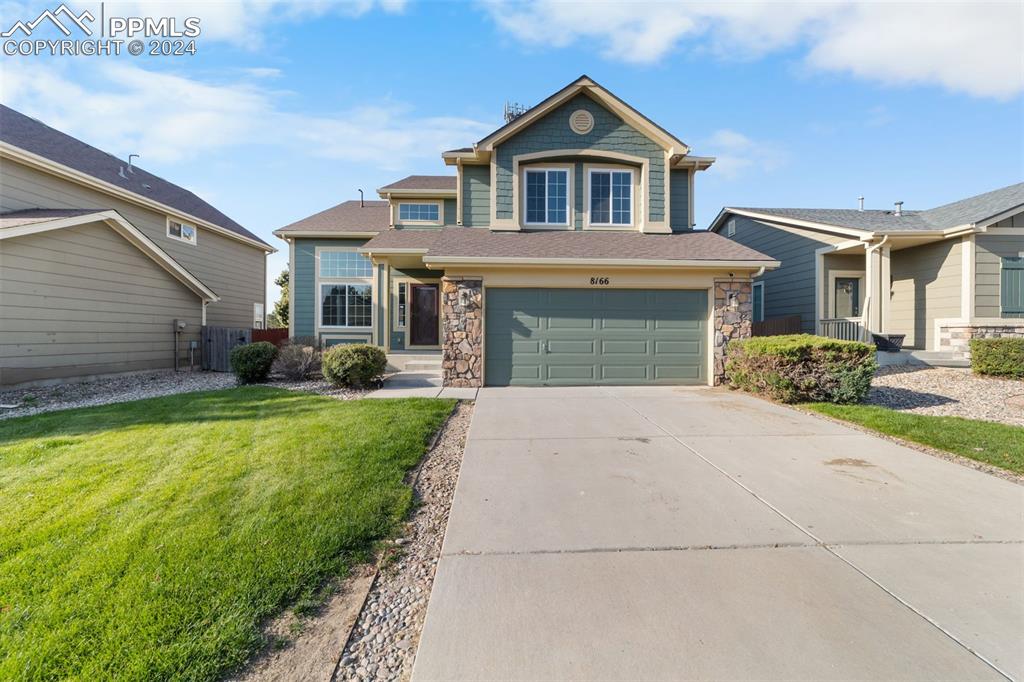 a front view of a house with a yard and garage