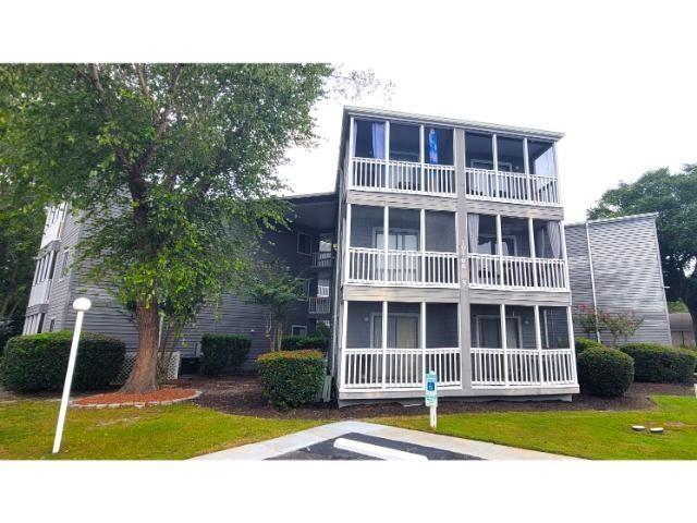 Back of property with a lawn and a balcony