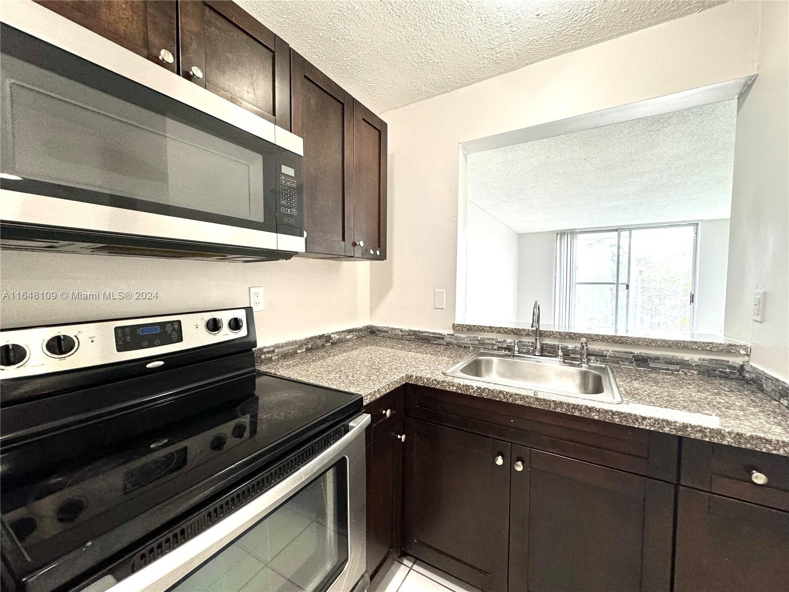 a kitchen with a sink stove and microwave