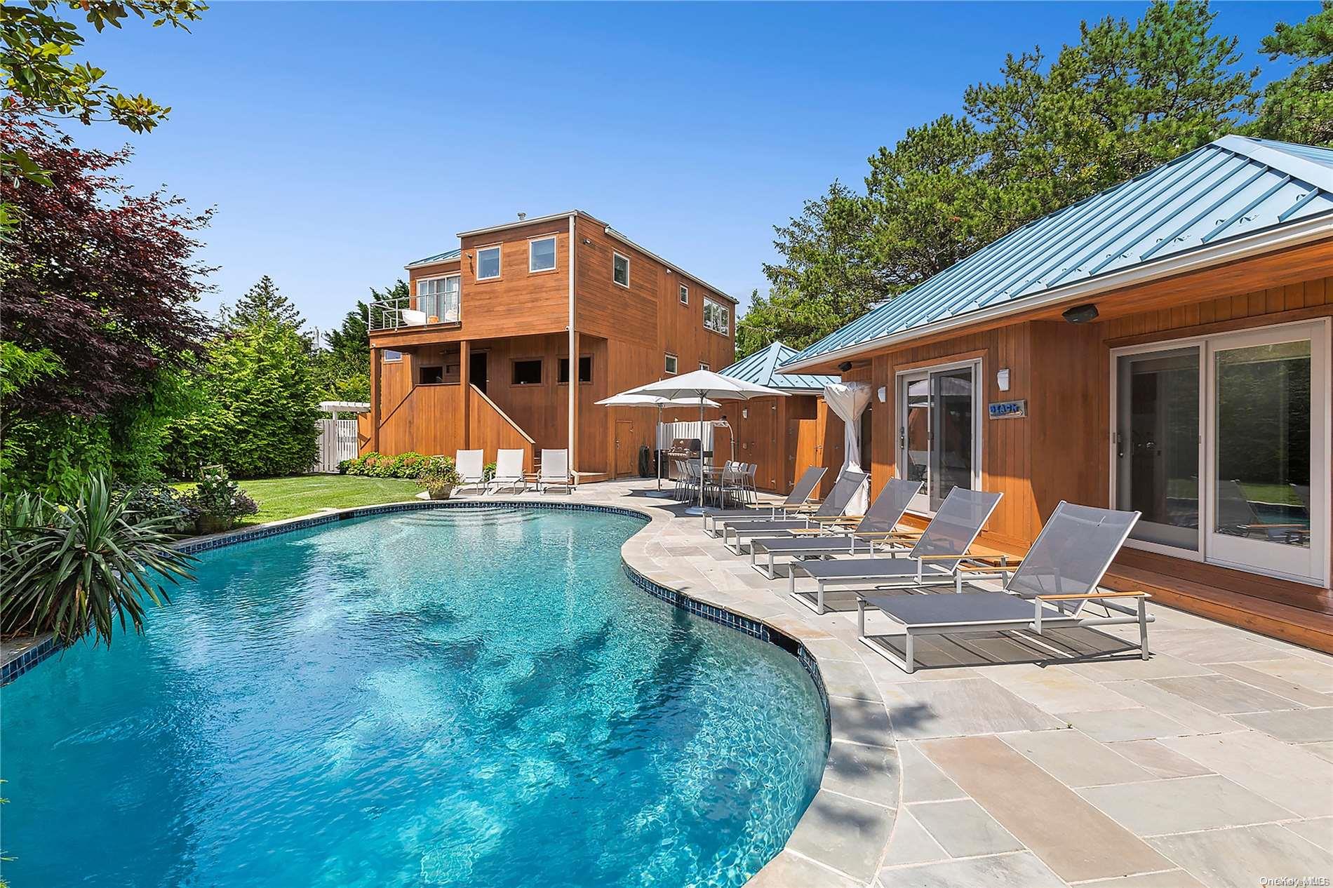 a view of a patio with table and chairs with wooden floor and fence and a barbeque