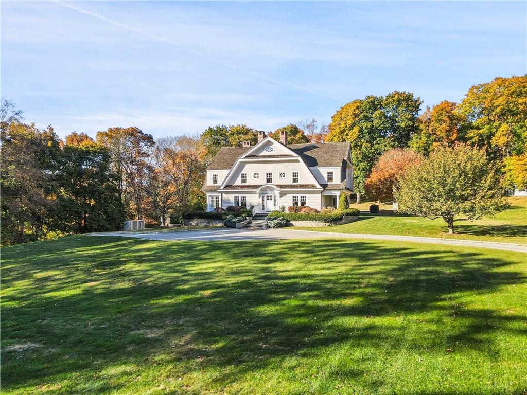 a view of a large house with a big yard and large trees