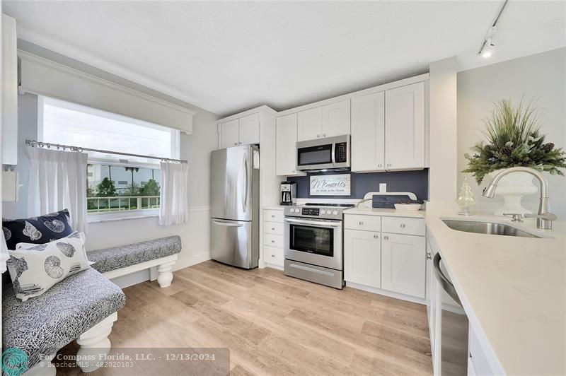 a kitchen with white cabinets and appliances