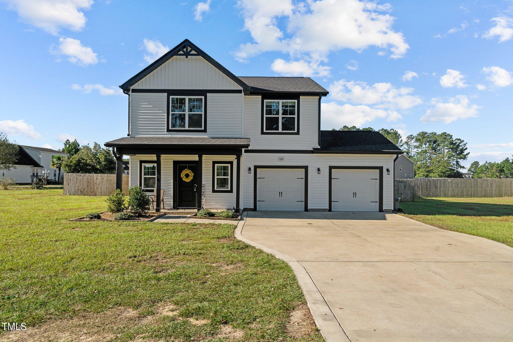 a front view of a house with yard outdoor seating and garage