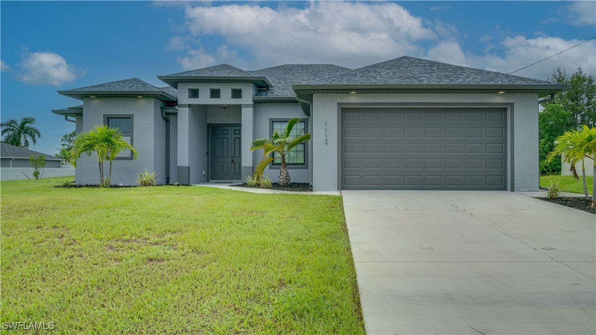 a front view of a house with a yard and garage