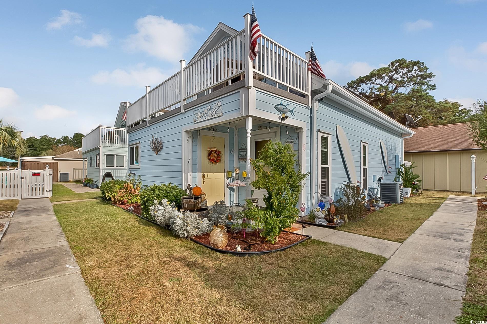 View of front of house featuring a balcony, a shed