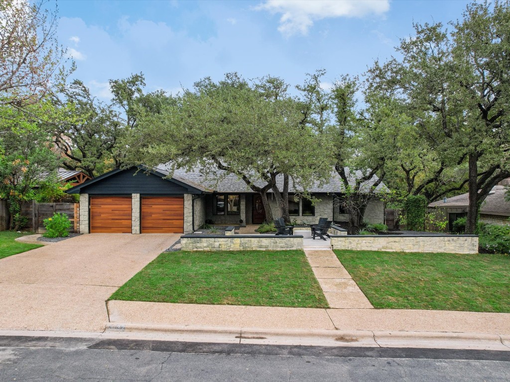 a front view of a house with a yard and trees