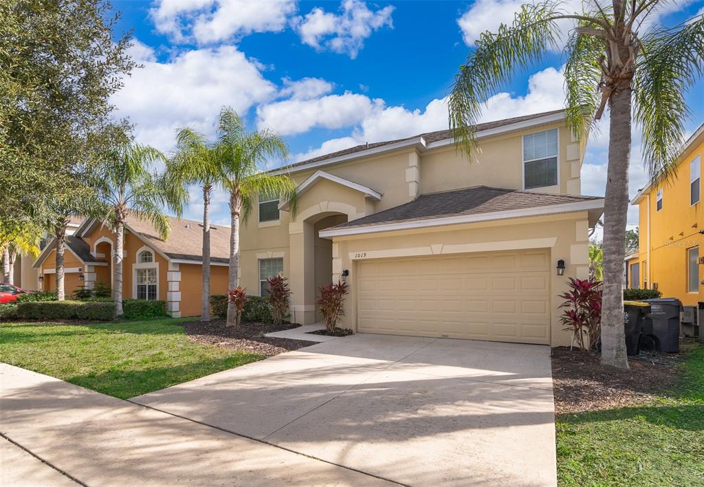 a view of a house with a yard and palm trees