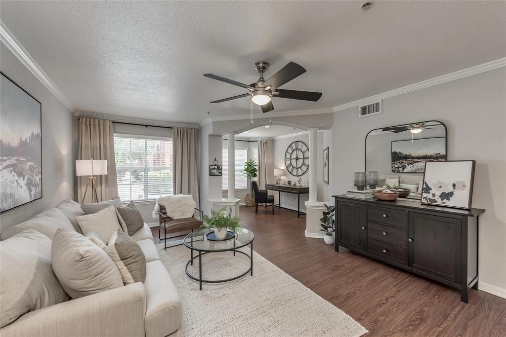 a living room with furniture kitchen view and a large window