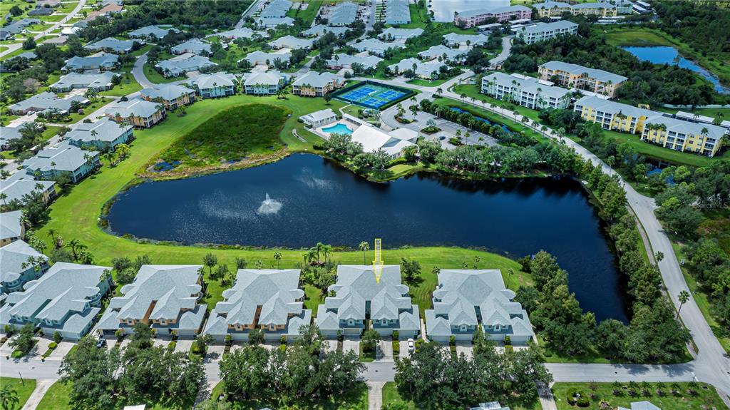 an aerial view of a house with a yard and lake view