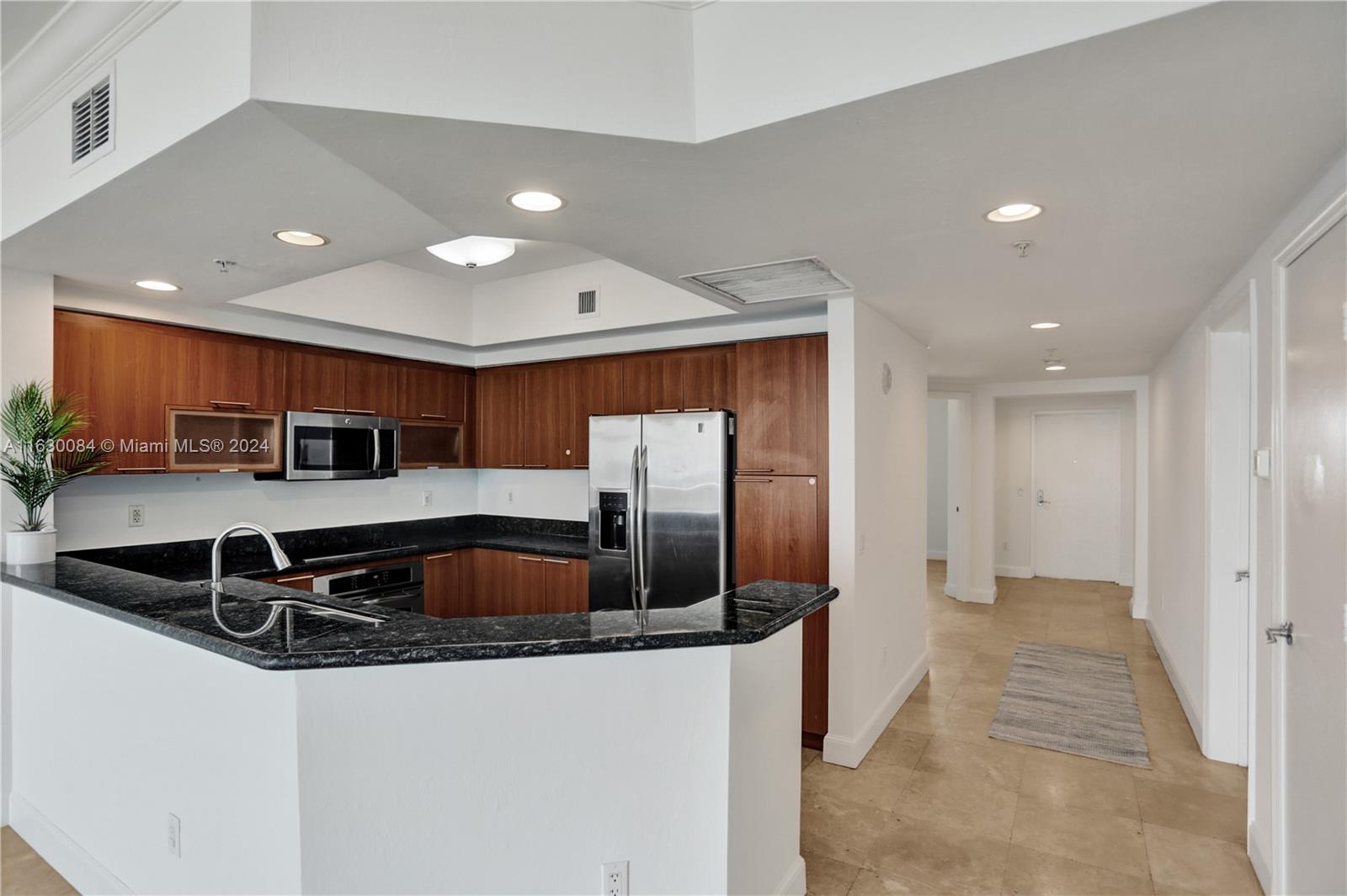 a kitchen with stainless steel appliances granite countertop a sink and a refrigerator