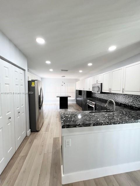 a large kitchen with stainless steel appliances kitchen island granite countertop a refrigerator and a sink